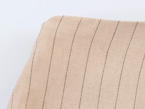 Vue macro détaillée du tissu en lin beige avec texture de fines rayures verticales marron