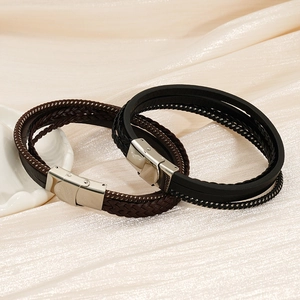 Detail von mehrlagigen geflochtenen Lederarmbändern mit polierten silbernen Magnetverschlüssen