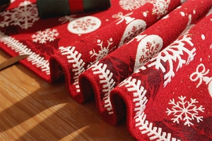 Close-up of red Christmas table runner featuring white snowflake patterns and thick woven texture