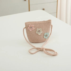 Détail du sac en paille tissé avec fleurs en tissu colorées et ornements de gemmes