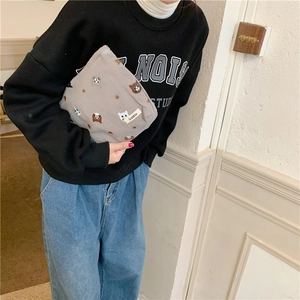 Close-up of Suzakka grey cotton bag featuring colorful cat embroidery and brand label