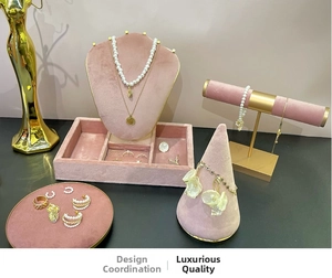 Luxurious pink velvet jewelry display stands with gold necklaces and pearl earrings