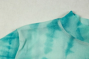 Close-up of the breathable lake green mesh fabric showing tie-dye pattern and seam detail