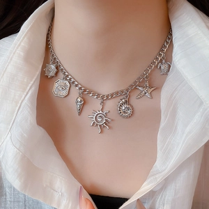 Detailed view of silver seashell and starfish charms on a chunky beach style necklace