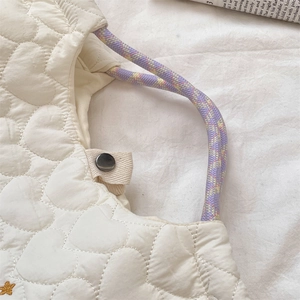 Détail du sac matelassé blanc avec motif cœur et poignées en corde tressée violette