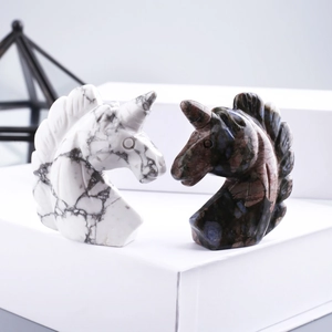 Pair of carved crystal unicorn head sculptures in marble white and dark mottled stone