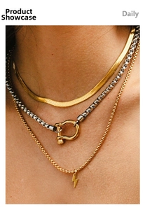 Detailed view of layered 18k gold plated stainless steel horseshoe and bolt necklaces