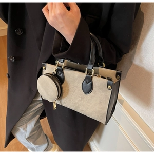 Detail of canvas tote bag with contrast leather trim, gold studs and round coin purse