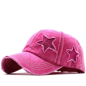 Dettaglio cappellino fucsia effetto usurato con stelle di paillettes e bordi sfrangiati