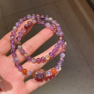 Detailed close-up of amethyst beaded bracelet with carved purple stone and round beads