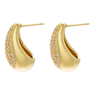Macro detail of teardrop gold earrings featuring pave-set cubic zirconia on curved surface