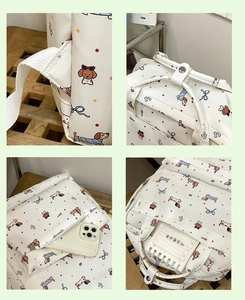 Detail view of white backpack with dachshund and bow patterns showing straps and side pockets