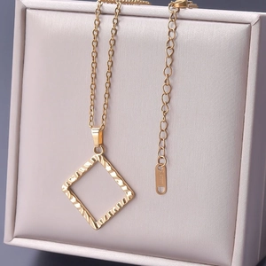 Makro-Detail des goldenen Viereck-Anhängers mit S.STEEL-Stempel auf Edelstahlkette
