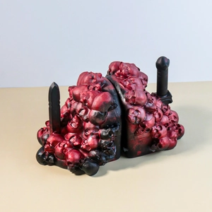 Macro view of gothic skull bookends with red and black resin texture and dual swords