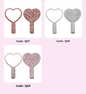 Macro shot of heart shaped hand mirrors with full rhinestone detailing in various colors