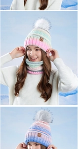 Détail du bonnet d'hiver en maille dégradée avec pompon en peluche et écusson en cuir