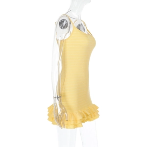 Detail of yellow ribbed knit mini dress featuring a layered ruffle hem and backless design