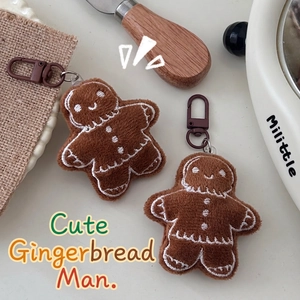 Cute gingerbread man plush keychain pair with embroidery on warm bakery setting