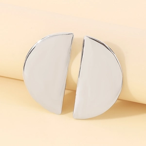 Detailed close-up of geometric semi-circle silver earrings with a mirror-finish texture