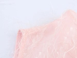 Dettaglio dell'abito rosa senza maniche con trama a frange delicate e tessuto effetto piuma