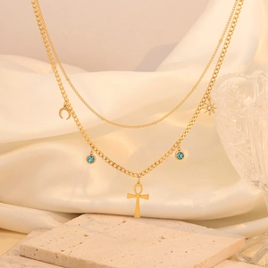 Double-layered gold necklace with Ankh cross, moon, star, and blue rhinestone pendants