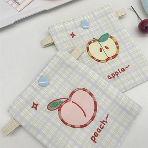 Close-up of cute embroidered apple and peach mini fabric storage bags with snap buttons