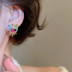 Detail of 3D floral earring with blue rose and gold base on ear for French vintage look