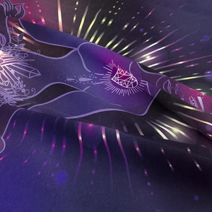 Macro texture of mystical astrology tapestry showing deep purple fabric and crystal patterns