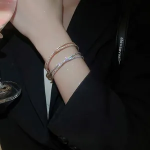 Bracelet croisé multicouche en zircone en finitions or et argent sur mannequin