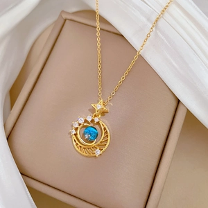 Detailed close-up of a gold celestial necklace with a blue stone on beige silk