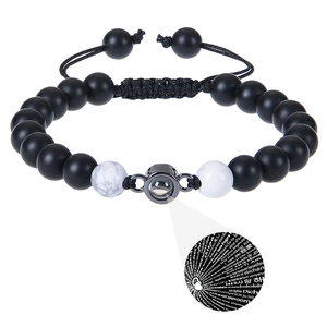 Macro detail of braided couple bracelet with 100 languages I Love You projection stone