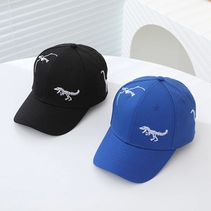 Close-up of black and royal blue baseball caps featuring dinosaur skeleton embroidery