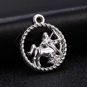 Macro detail of silver Sagittarius zodiac charm pendant with woven rope border on black leather