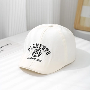 Détail du béret blanc pour enfant avec broderie noire de visage souriant et de lettres