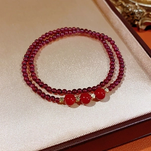 Detail of red garnet and southern red agate bracelet with gold accents in jewelry box