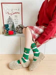 Detail of soft green coral fleece Christmas sock with festive dots and warm texture