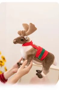Close-up of plush reindeer doll with festive scarf held by hands in a warm home setting