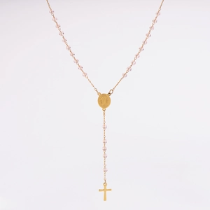 Détail d'un collier doré avec perles roses, médaillon religieux et pendentif en croix
