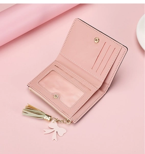 Detail view of pink foldable wallet showing card slots and clear ID window with tassel