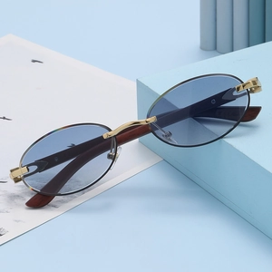 Detalle de gafas de sol ovaladas al aire con lentes azul claro y patillas de madera