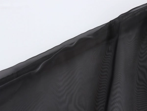 Gros plan sur le tissu en organza noir élégant avec une texture de maille fine et coutures
