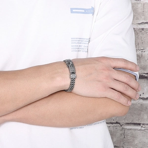 Gros plan d'un bracelet en acier inoxydable tressé argenté vintage pour homme avec fermoir