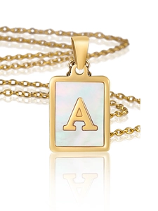 Vue macro d'un pendentif carré doré en nacre avec la lettre A sur chaîne fine