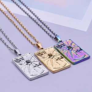 Detailed view of three stainless steel sunburst rectangular pendants in gold, silver and rainbow