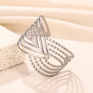 Macro detail of silver geometric wide cuff bracelet with layered V-shapes and beaded lines