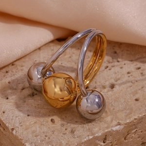 Macro view of two-tone 18K gold plated stainless steel triple ball ring on stone