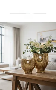 Lot de deux vases en céramique dorée martelée avec design évidé et décor floral