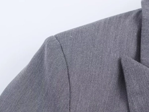 Vue macro détaillée des coutures d'épaule et de la texture du tissu sergé gris du blazer