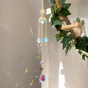 Regenbogen Sonnenfänger mit goldenem Mond und bunten Kristallprismen am Baumzweig