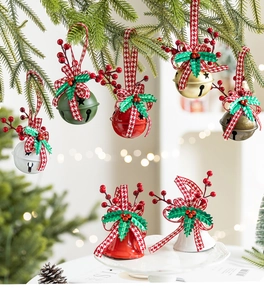 Close-up of festive Christmas bells with plaid ribbons and holly leaves on tree branch